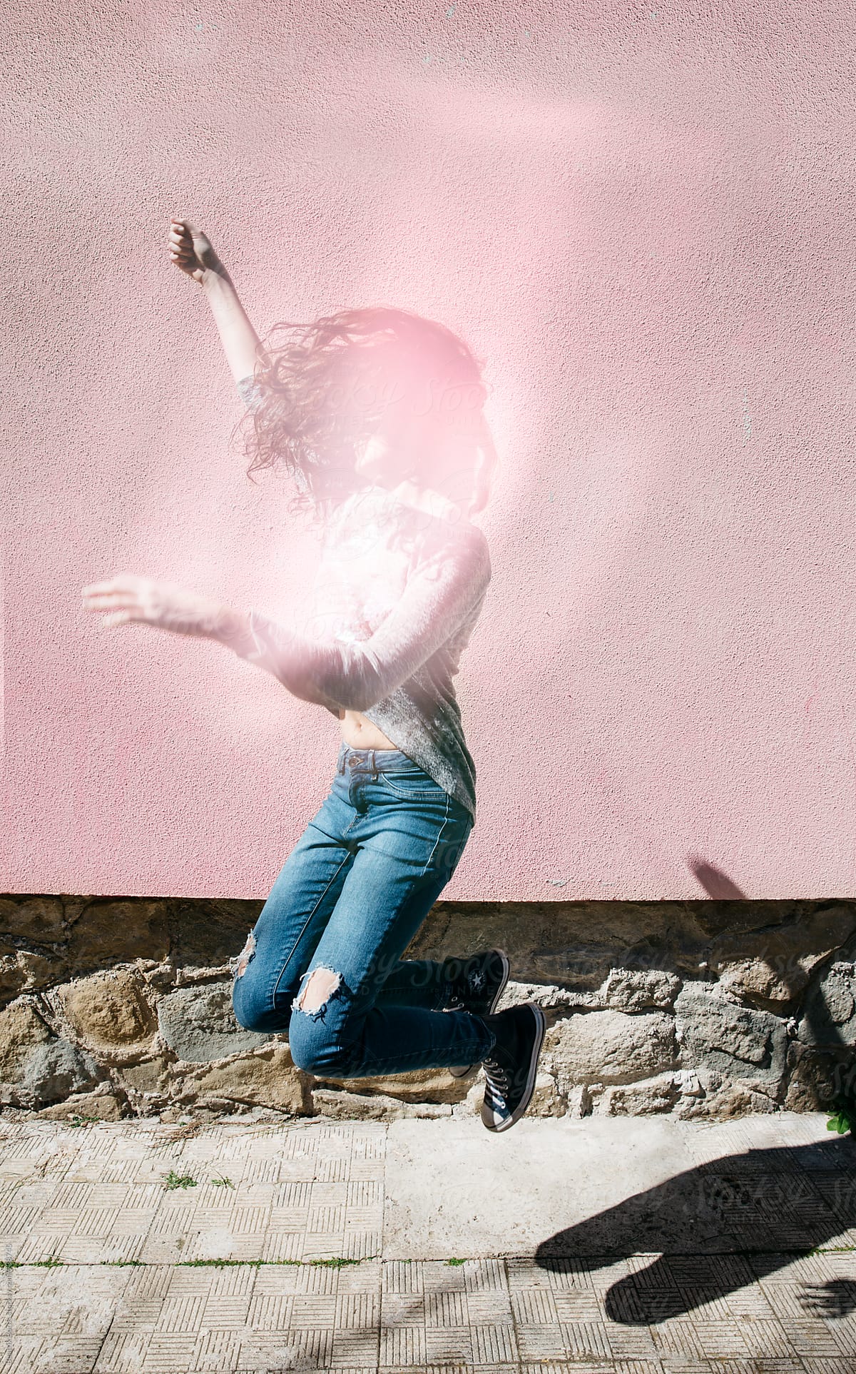 Young Woman Jumping In The Air Her Face Is Covered By Light Reflection By Stocksy Contributor 1572