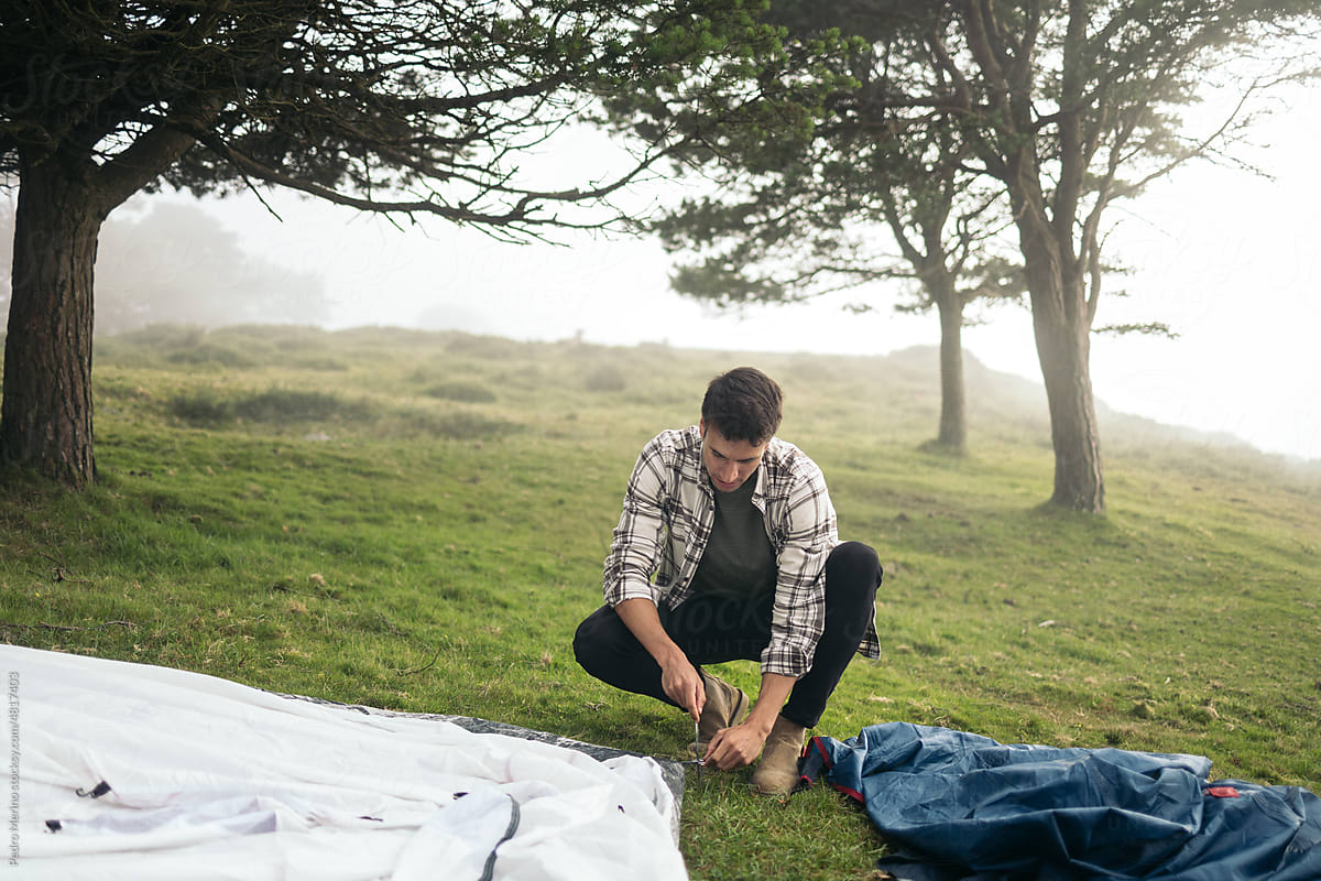 Man setting up a tent in the forest
