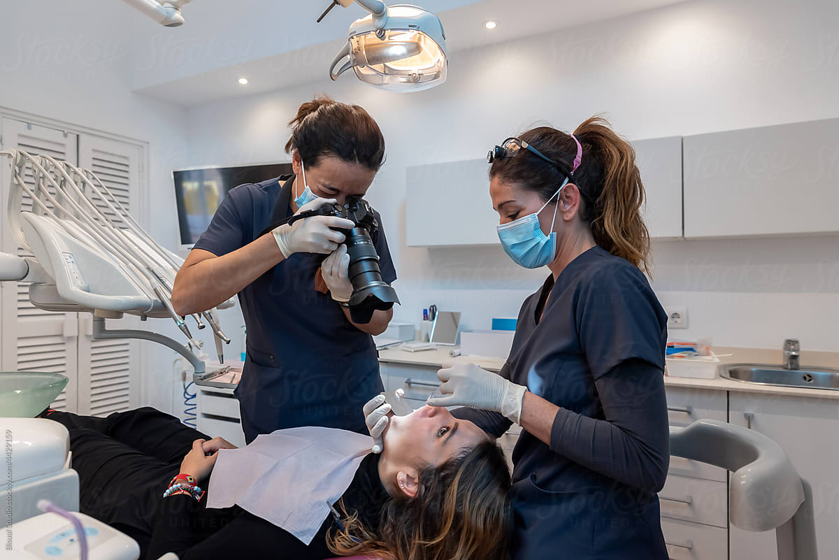 Dentist photographing patient teeth during treatment
