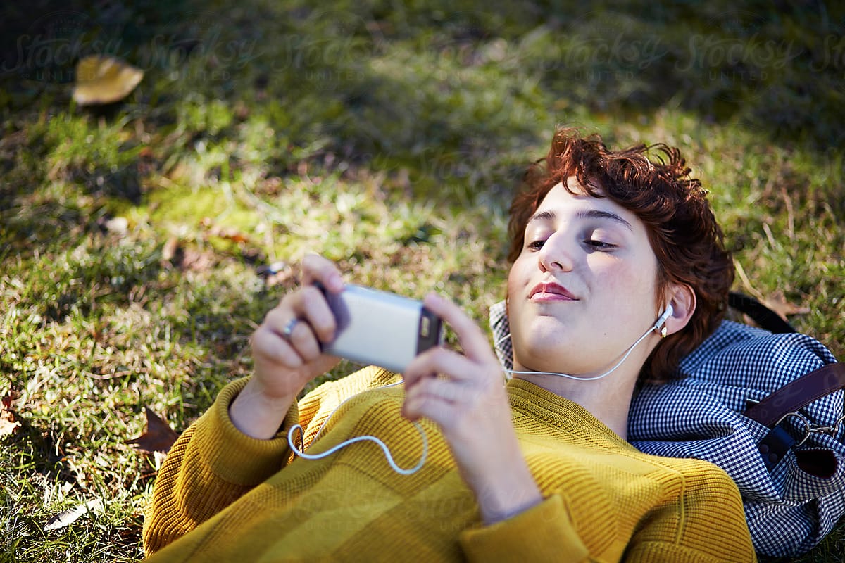 Happy young woman watching her smartphone