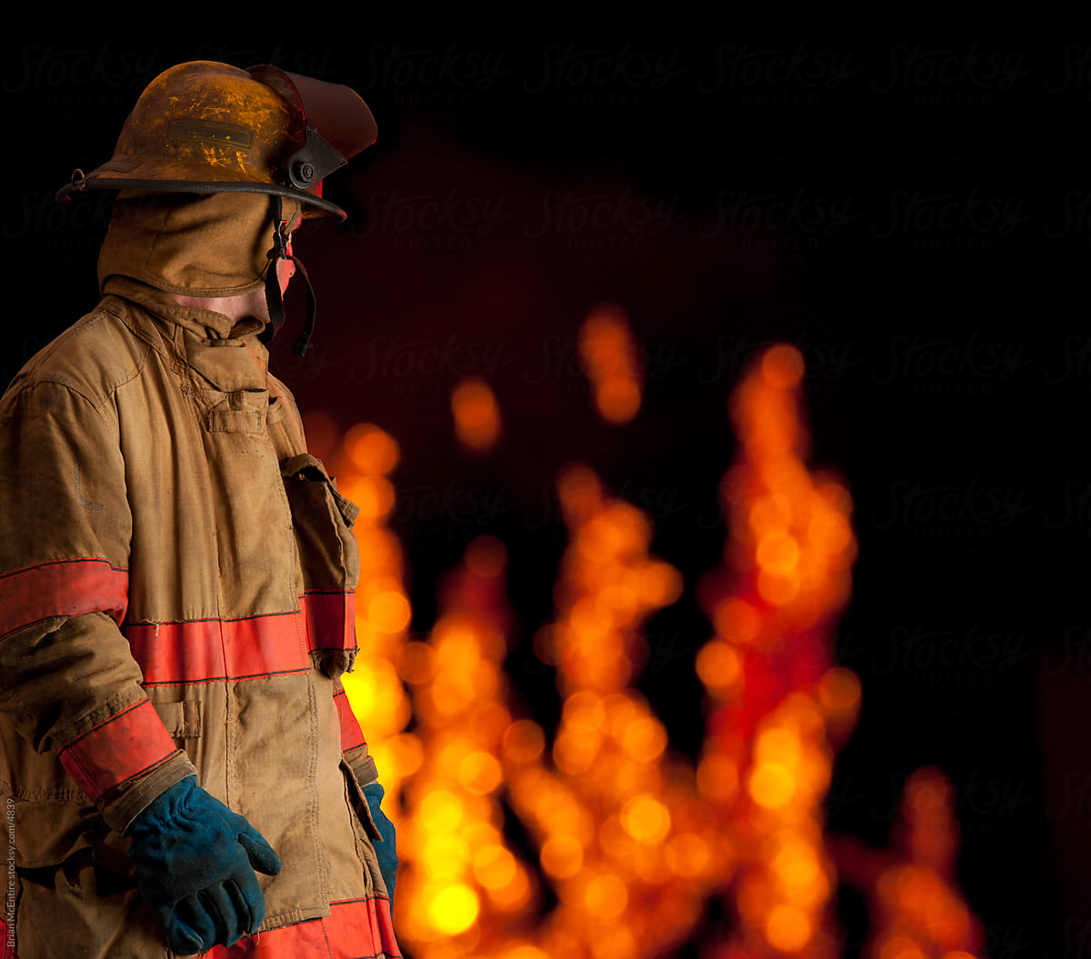 Fireman looks back at flaming building