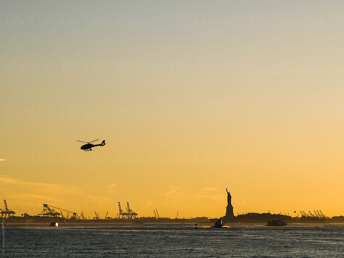Helicopter and boats against Statue of Liberty in NY