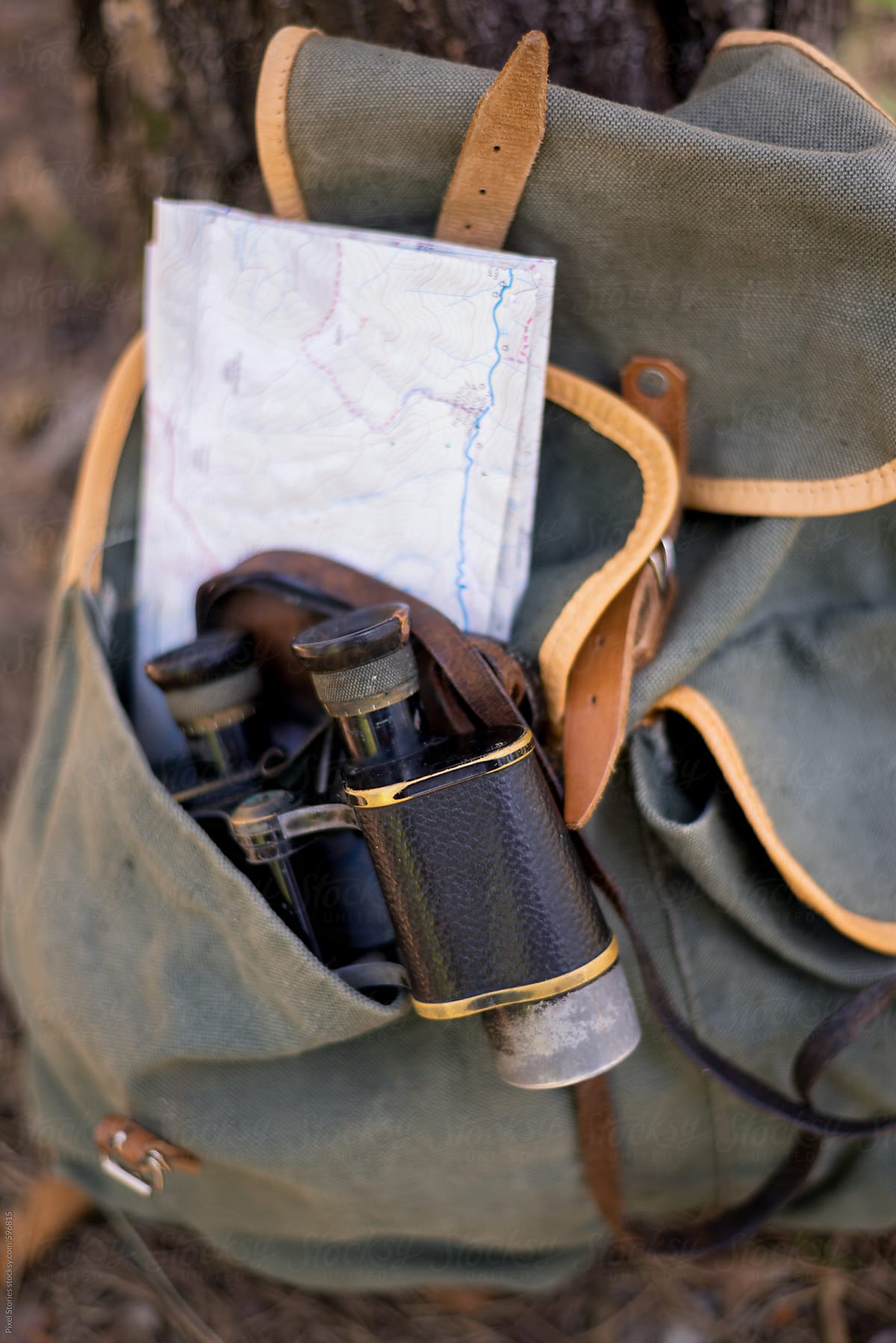Old binoculars and a map tucked into a backpack