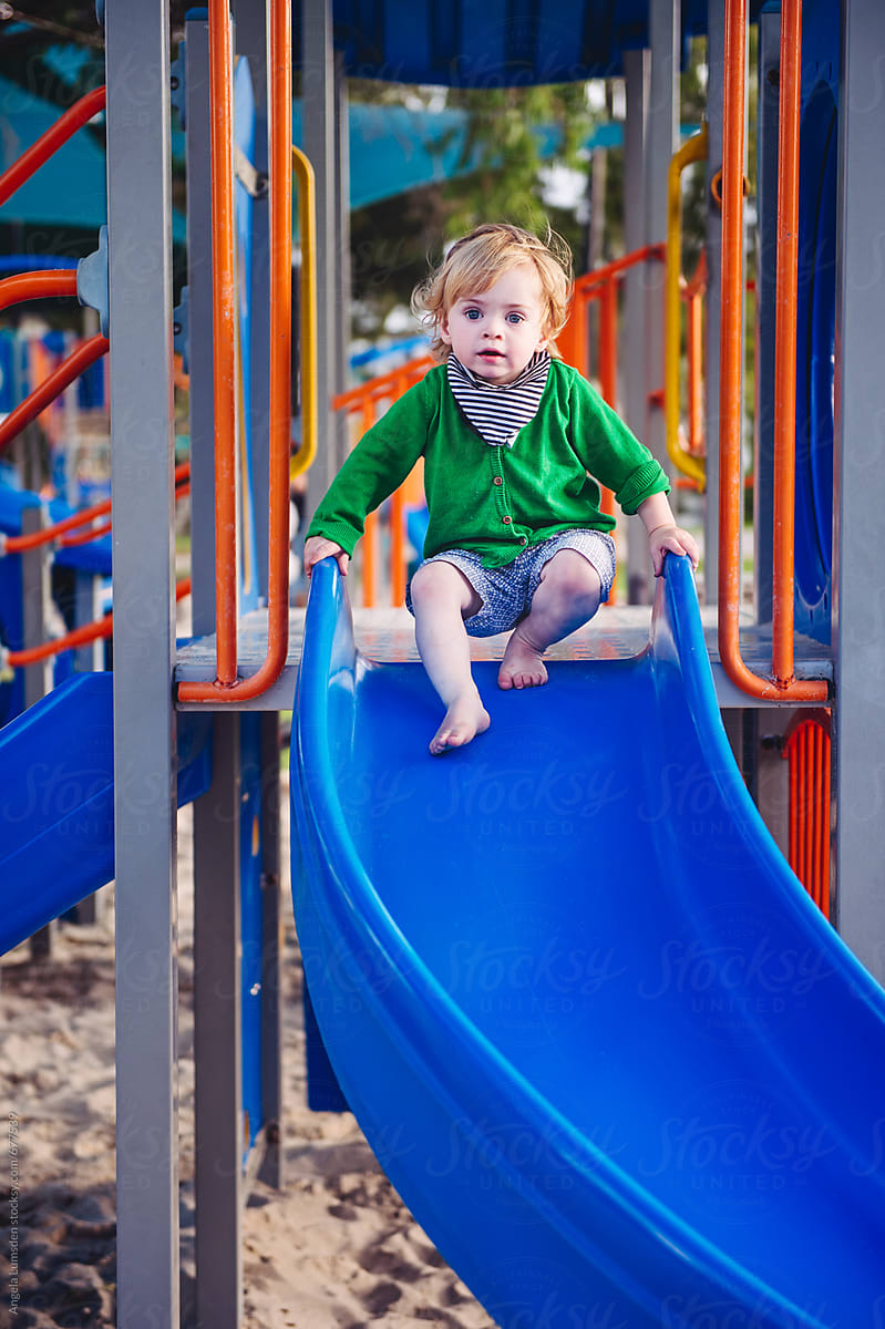 Little Girl Sliding Down Playground Slide Stock Photo, Picture and