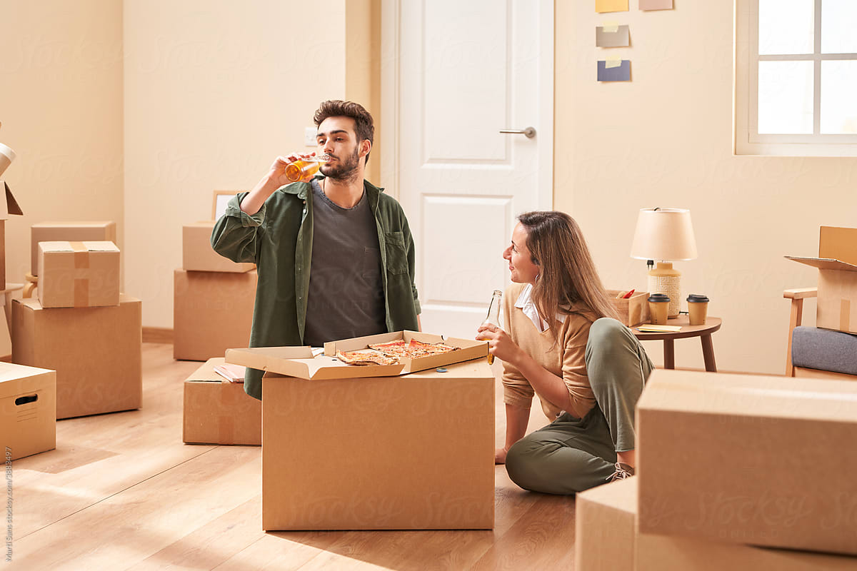 Young couple drinking beer in new apartment