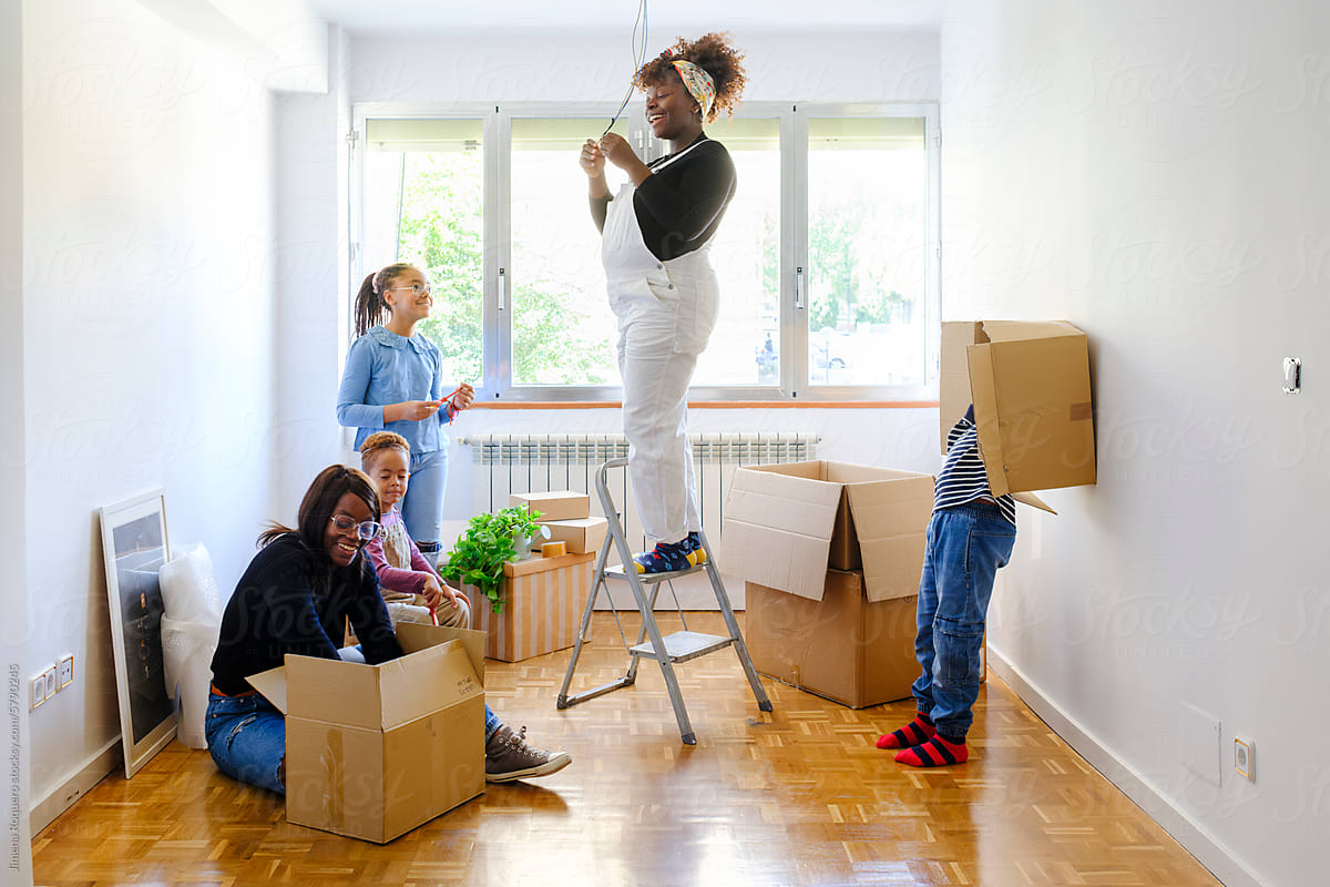 Members of family unpacking boxes in new home