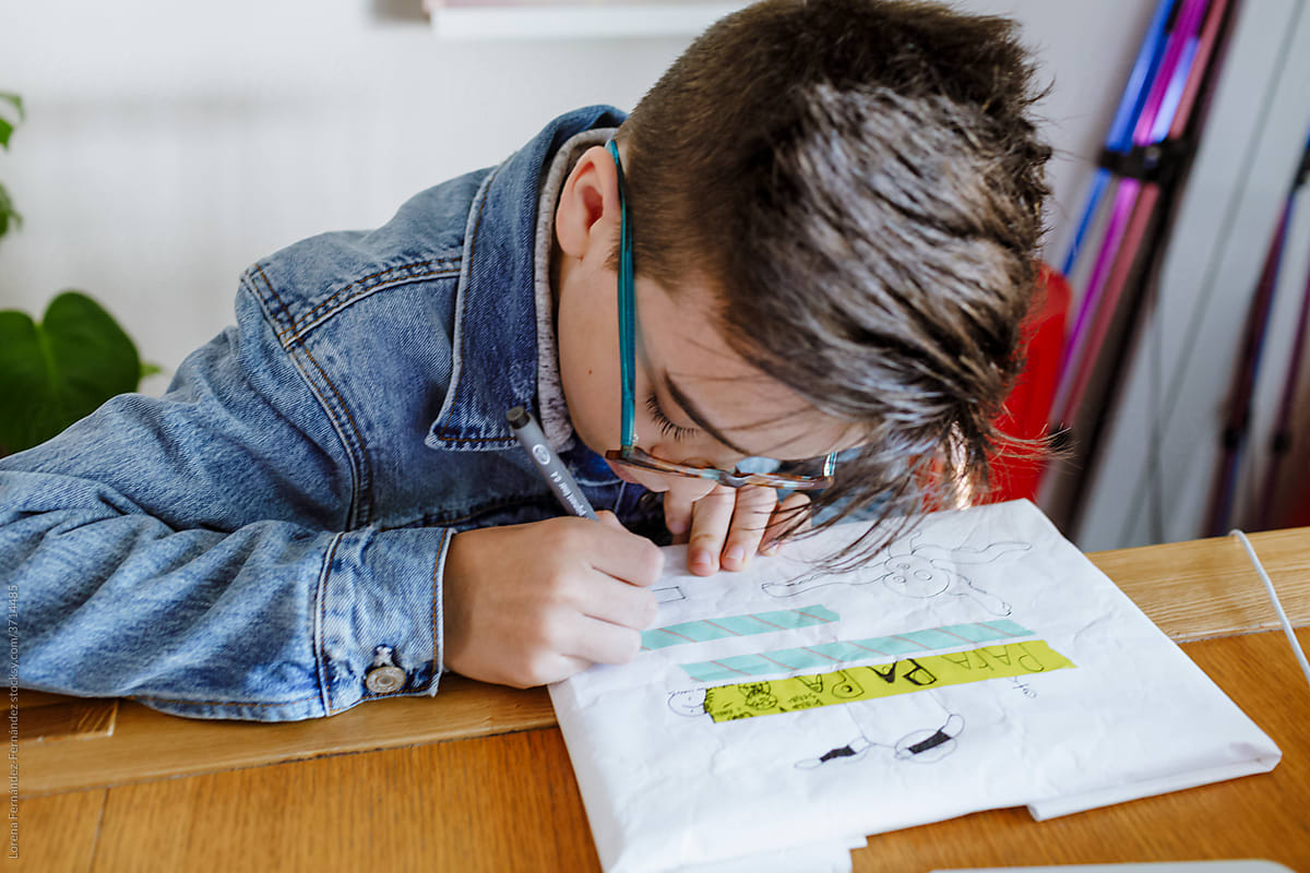 Teen Boy writing on white gift  paper \