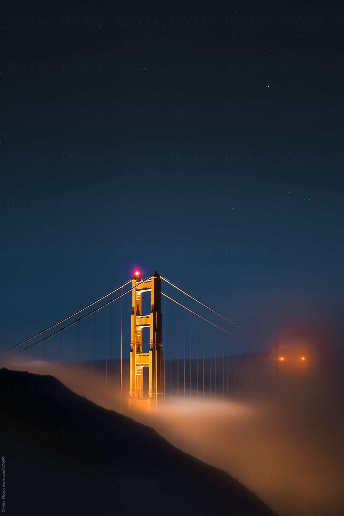 Night fog rolls under the Golden gate Bridge
