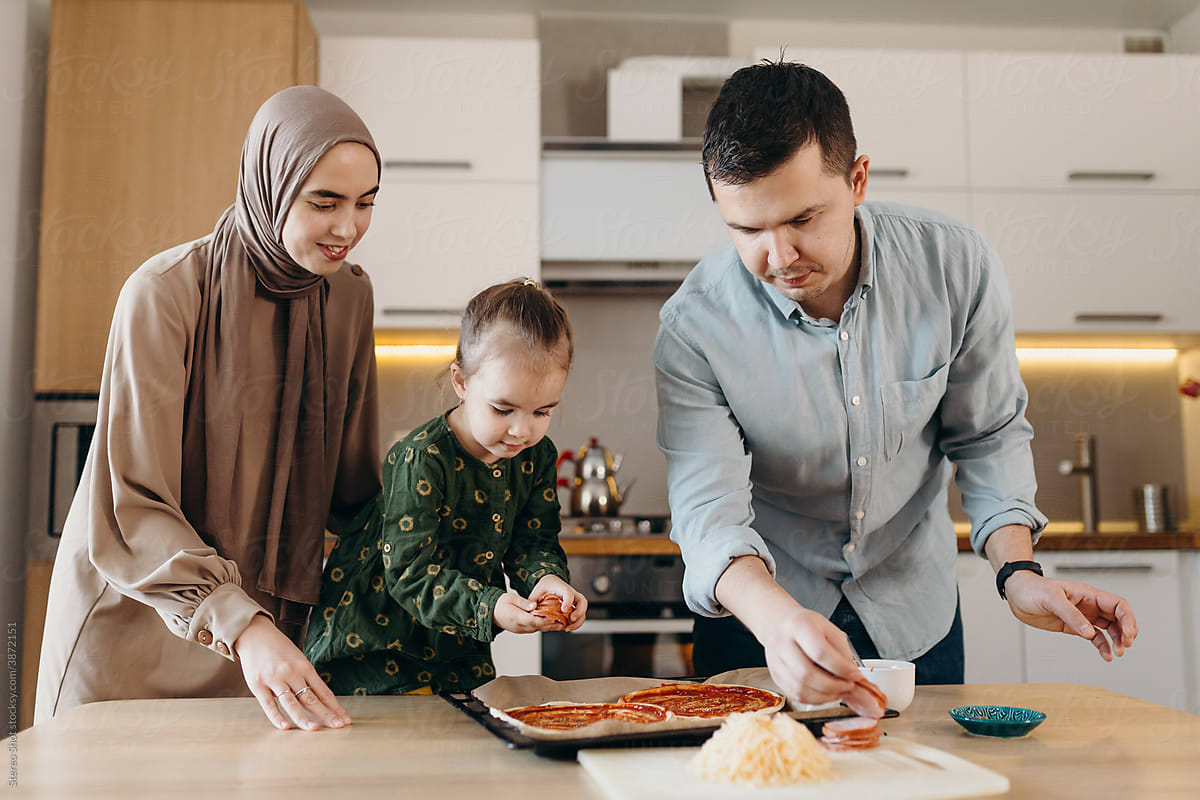 muslim parents and daughter preparing lunch together