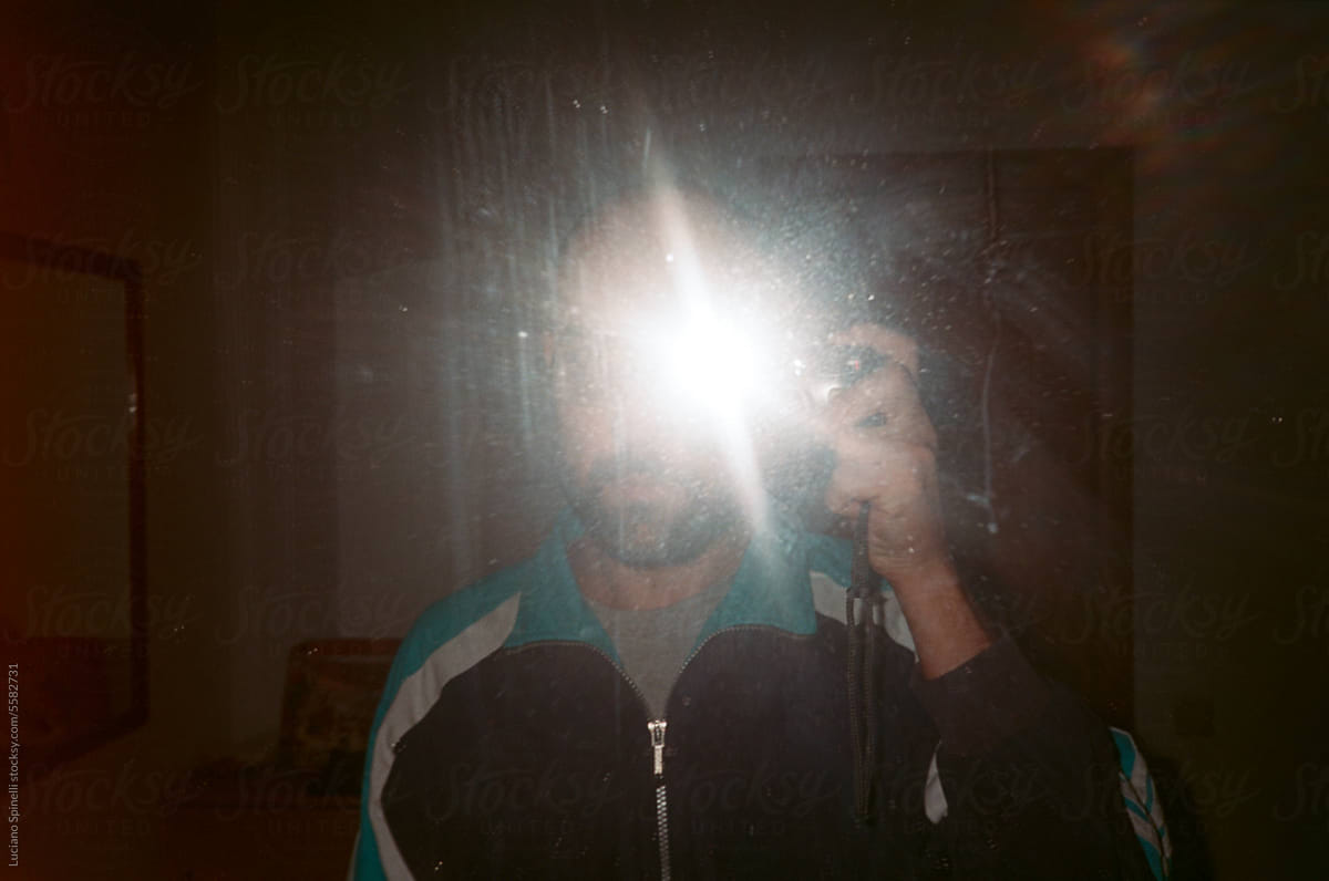 Analog flash mirror selfie: anonymous bald man vintage self-portrait