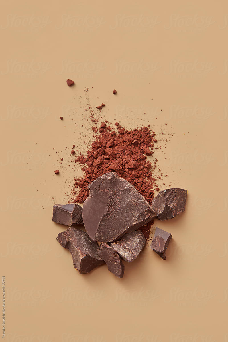 Pieces of chocolate and cocoa powder in studio