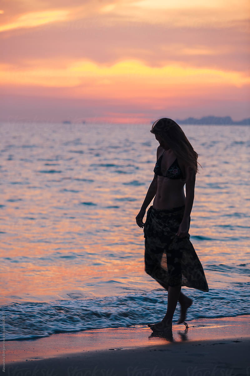 Beautiful Woman Silhouette Walks On The Beach At Sunset By Stocksy Contributor Alexandra 