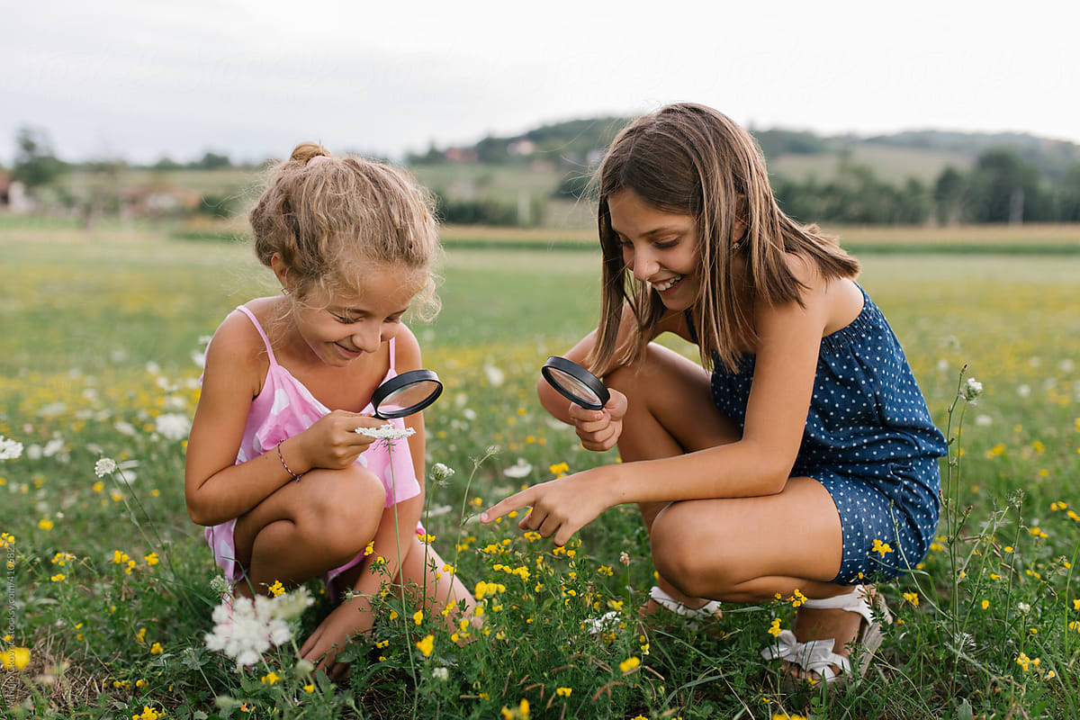 Girls looking at flowers with magnifying glass