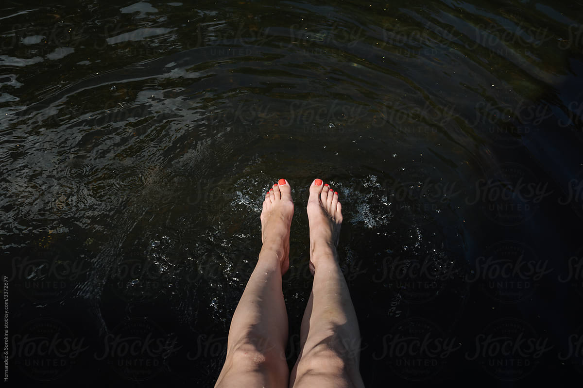 Woman Legs In The Lake Water