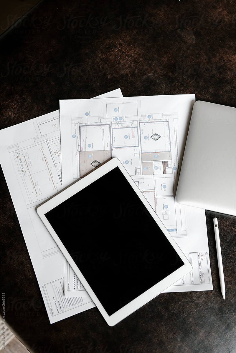 Workplace of modern engineer with tablet, plans and maps.