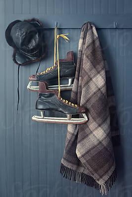 Men's Vintage Skates And Sweater Hanging On Hooks by Stocksy