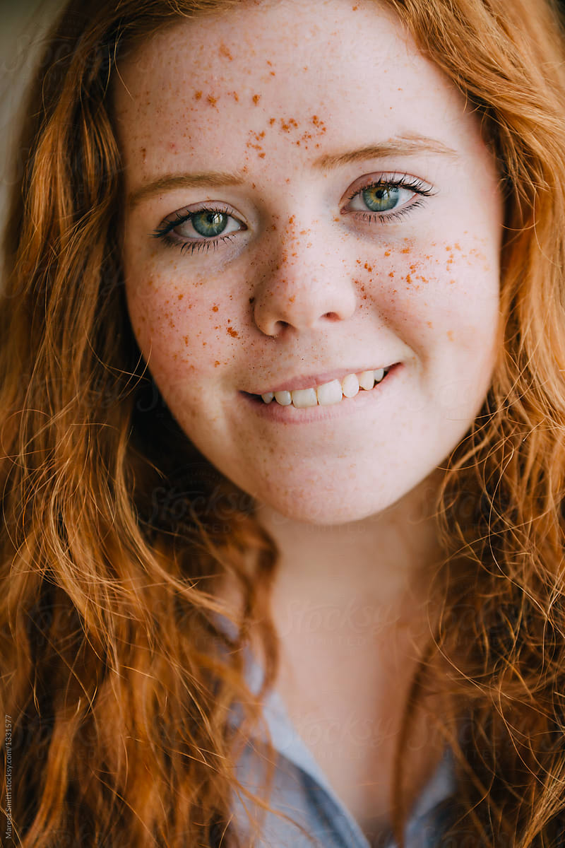Close Up Portrait Of A Teenage Girl With Freckles And Ginger Hair, Biting H...