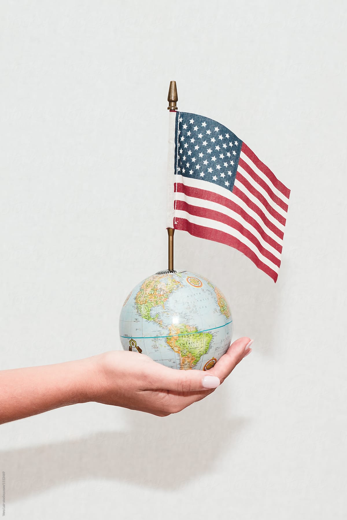 Hand holding a small world and american flag