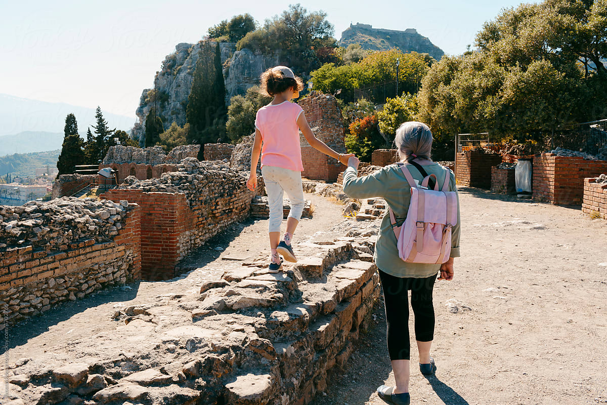 Kid and woman walking on ancient Greek ruines in Taormina, Sicily