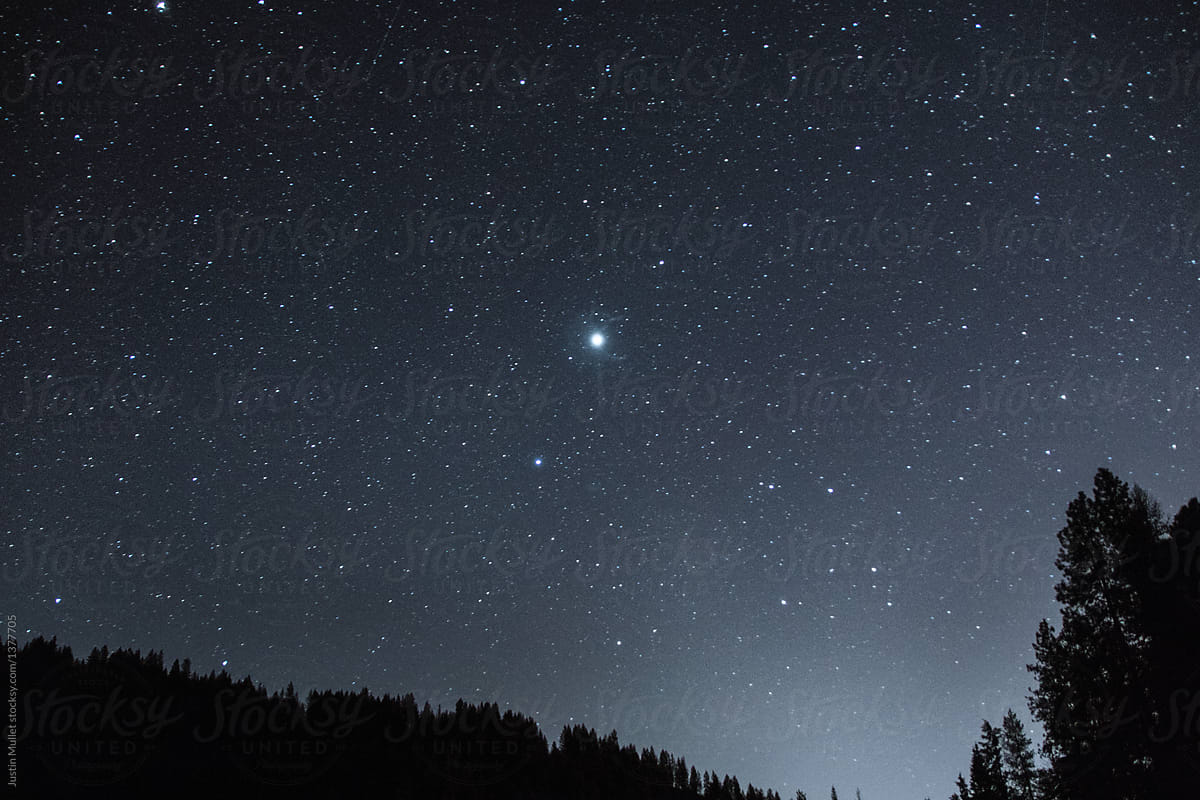 Very bright star in the night sky. by Justin Mullet Stocksy United
