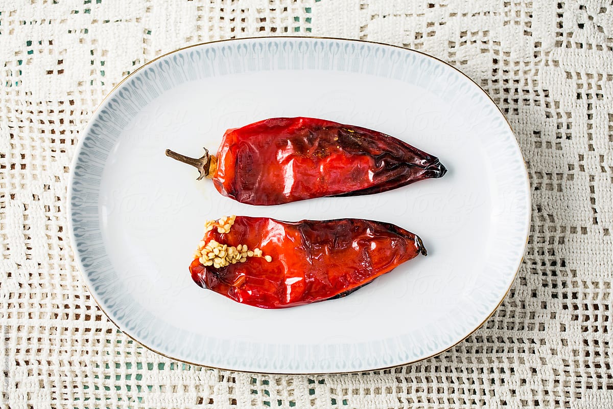 Two roasted red peppers on vintage plate