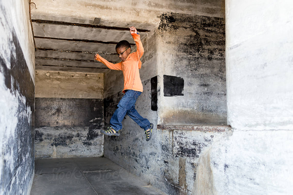 Boy jumps from concrete ledge