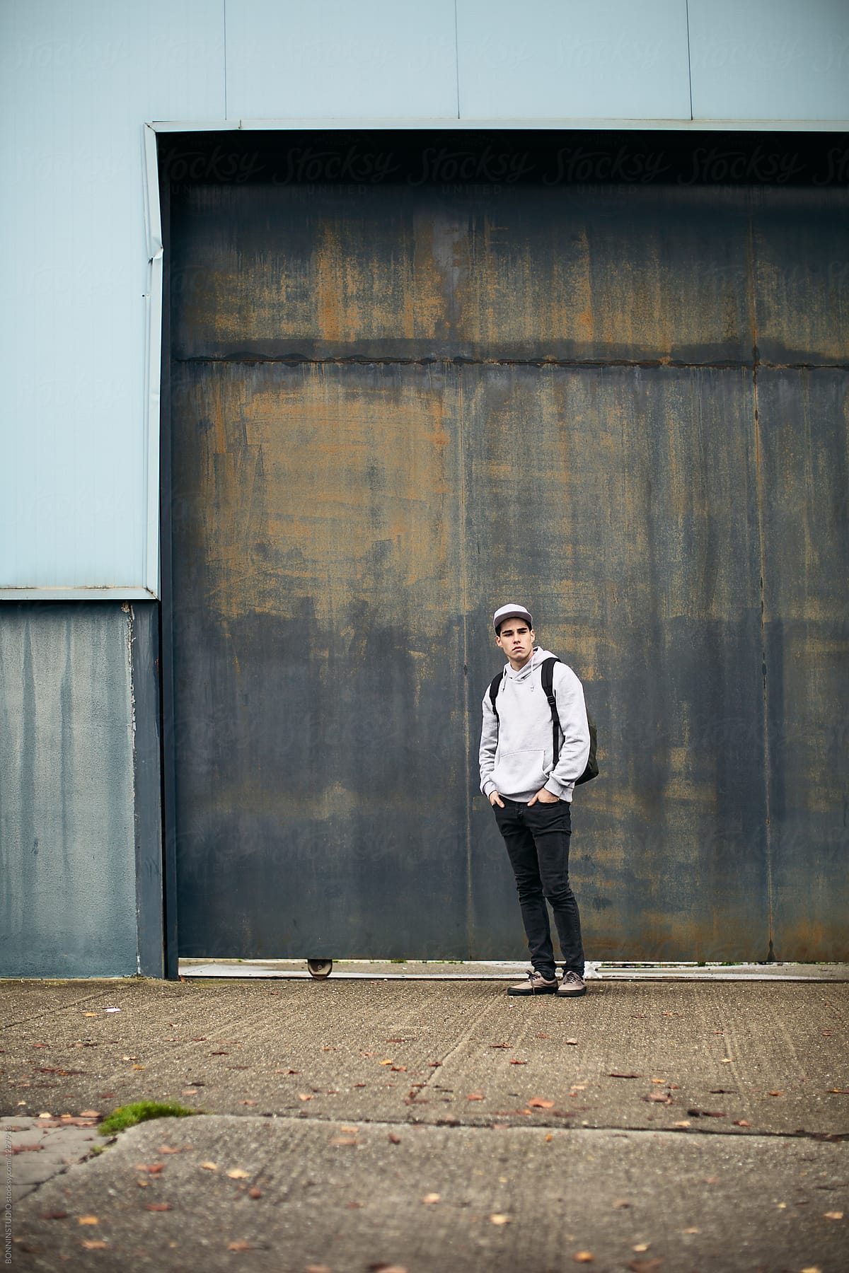 Young Modern Man Standing In Front Of An Urban Background. by Stocksy  Contributor BONNINSTUDIO  - Stocksy