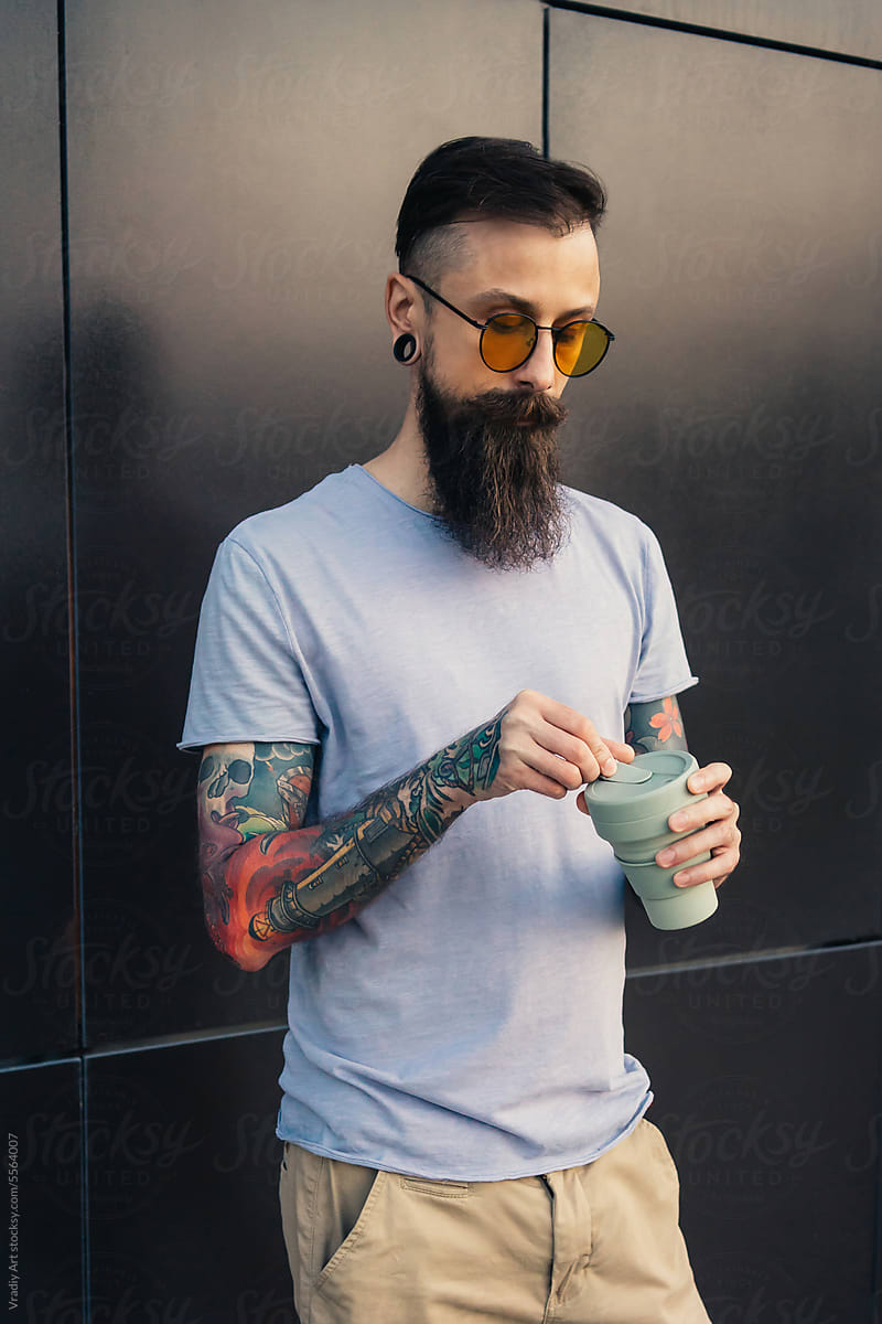Young man in sunglasses with reusable cup
