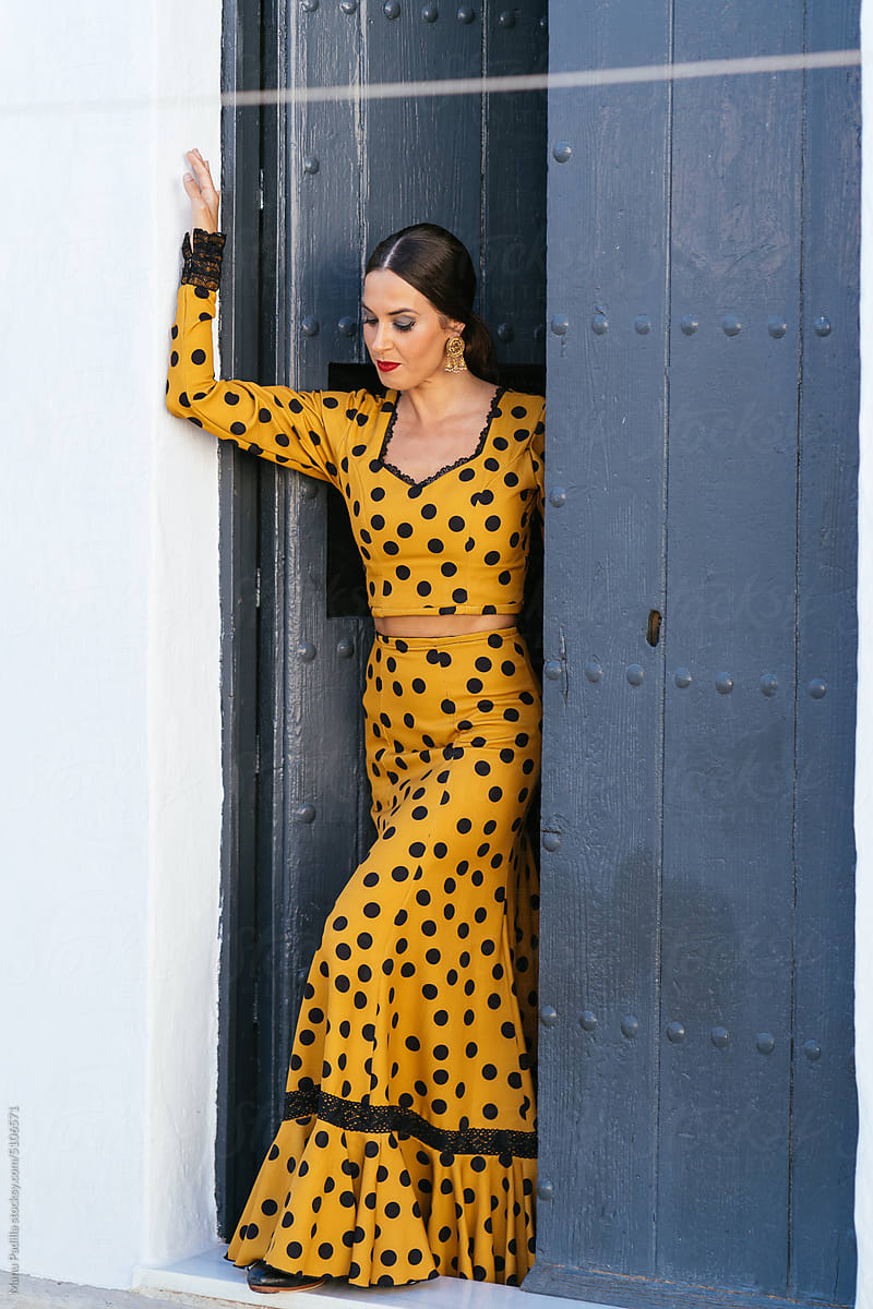 Calm Hispanic woman in flamenco dress in doorway