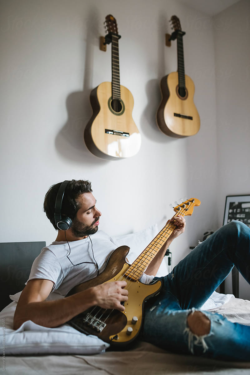 Man playing bass guitar at home