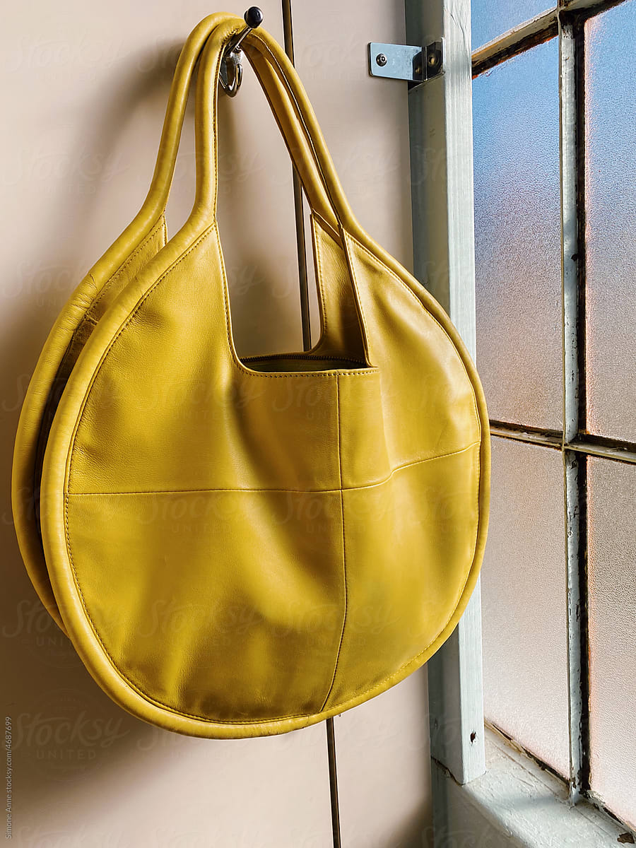 Round yellow purse hangs in bathroom