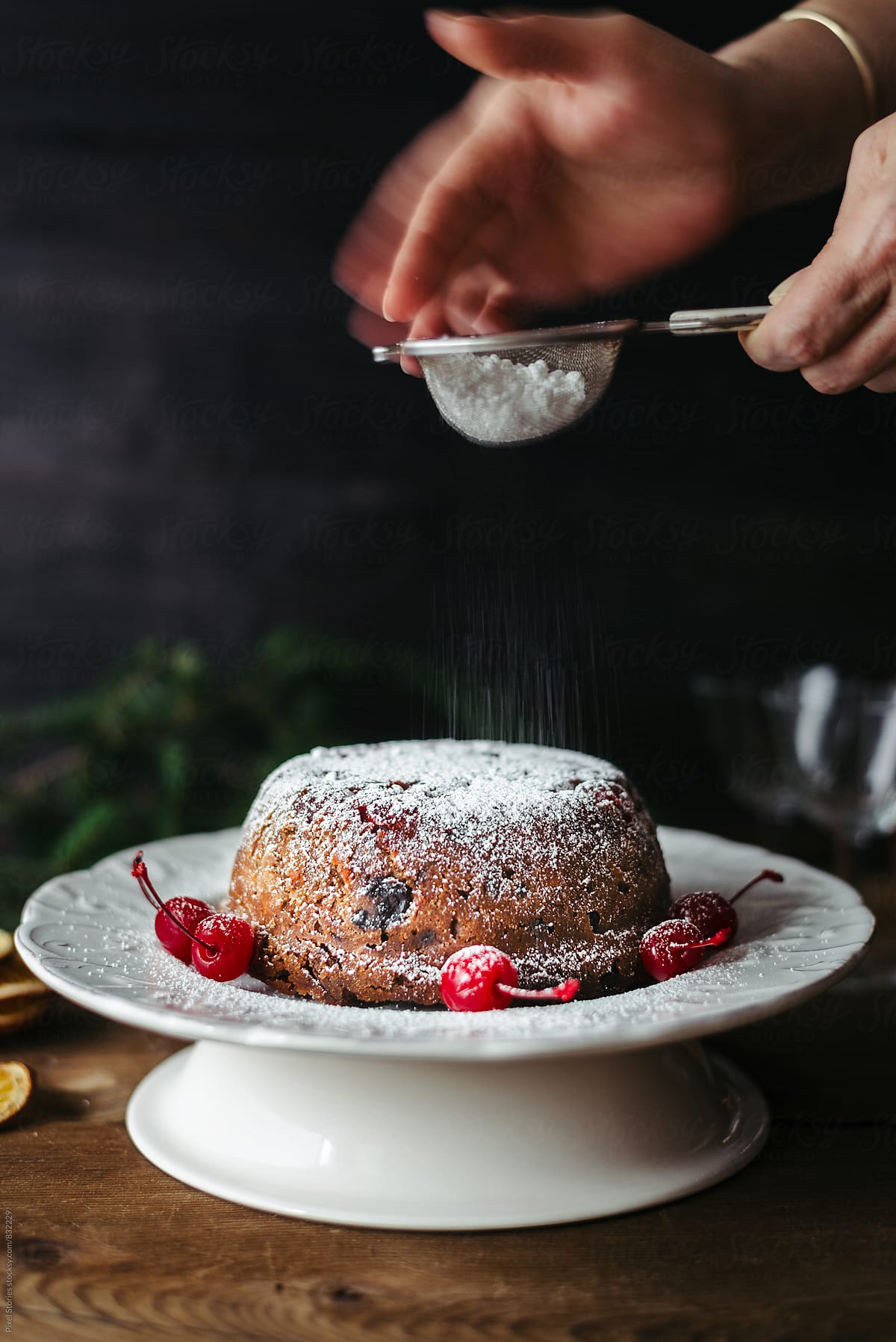 Dusting Christmas pudding with powdered sugar
