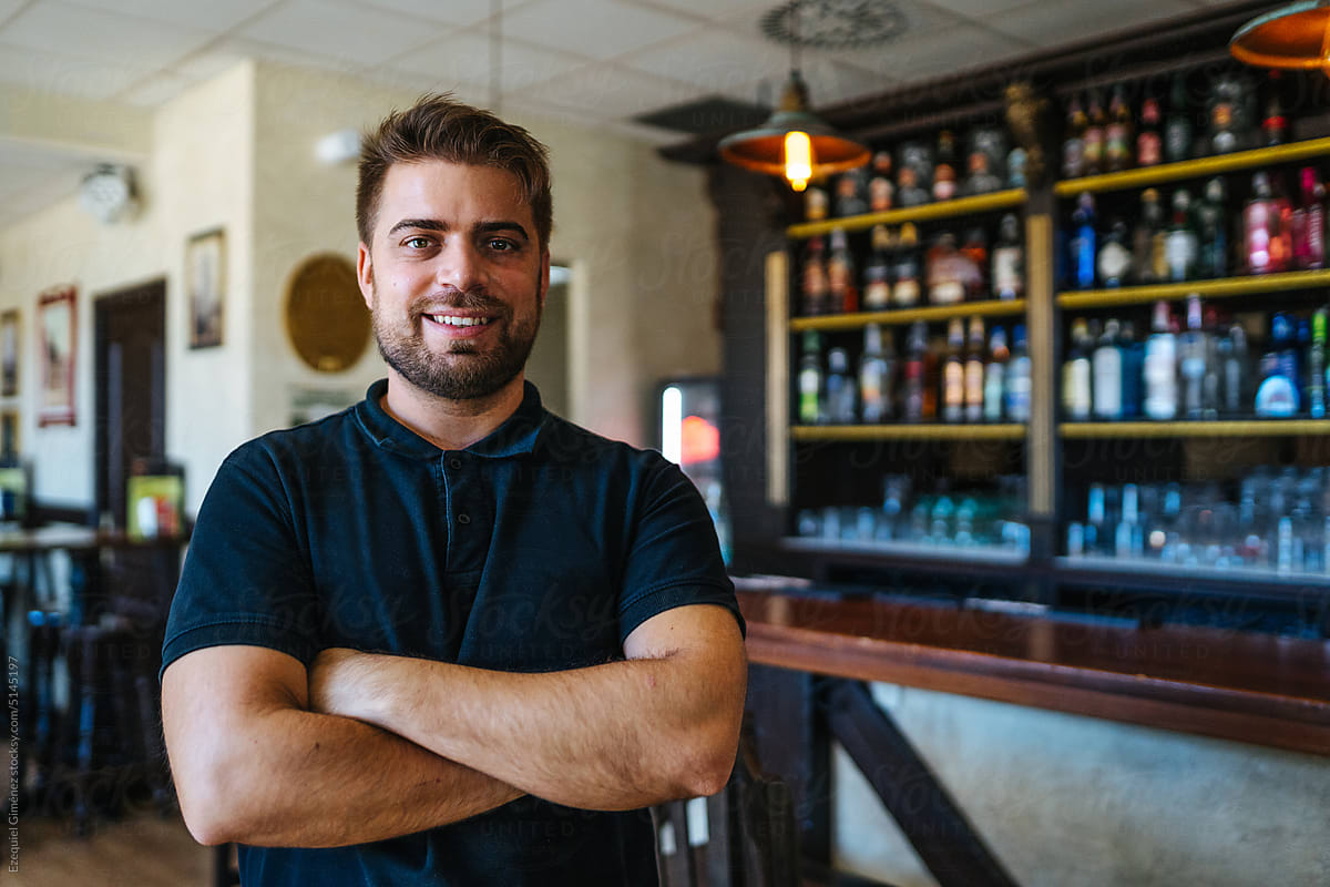 Confident male bartender with crossed arms