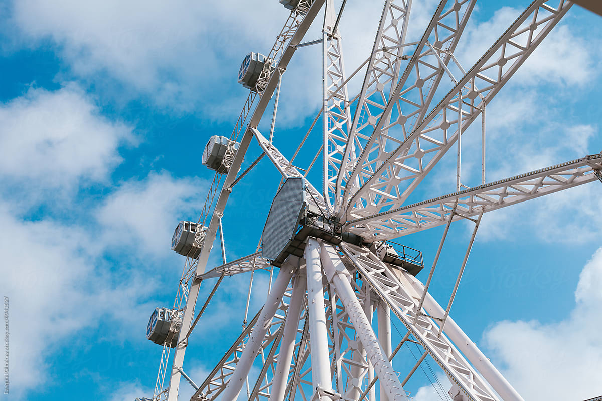Ferris wheel against cloudy blue sky