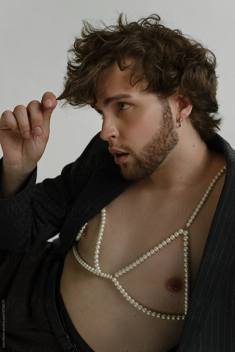 Sexy bearded guy in a pearl bra & suit with pierced nipples & curls