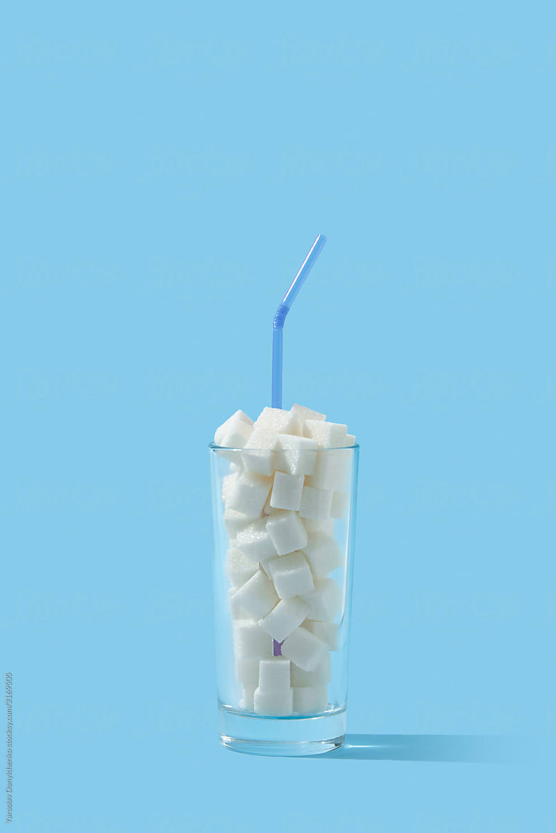 Glass filled sugar cubes with plastic straw.