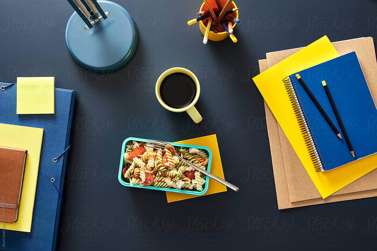 Top view of lunch in lunchbox with yellow cup of coffee