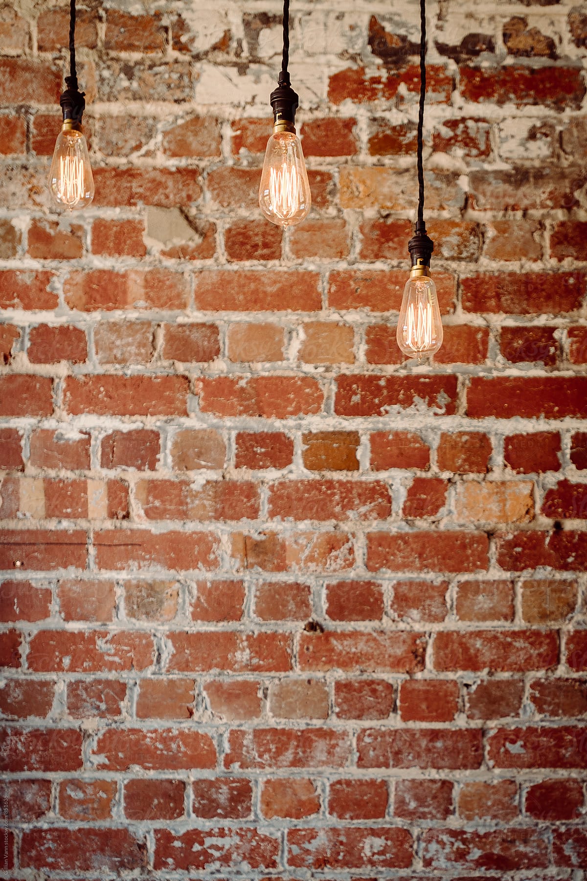 Brick Wall With 3 Hanging Pendant Lights" Contributor "Gillian Vann" - Stocksy