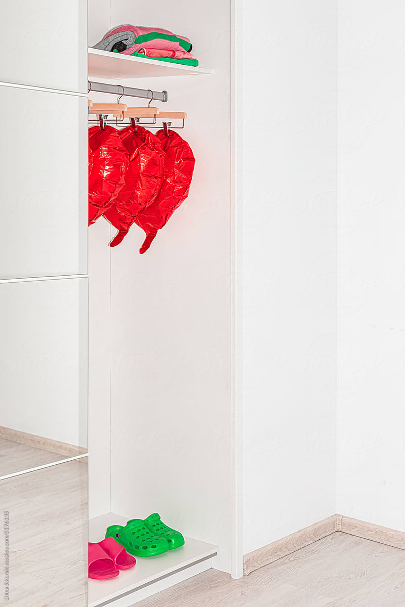 A lot of heart-shaped balls are hanging on a hanger in the closet