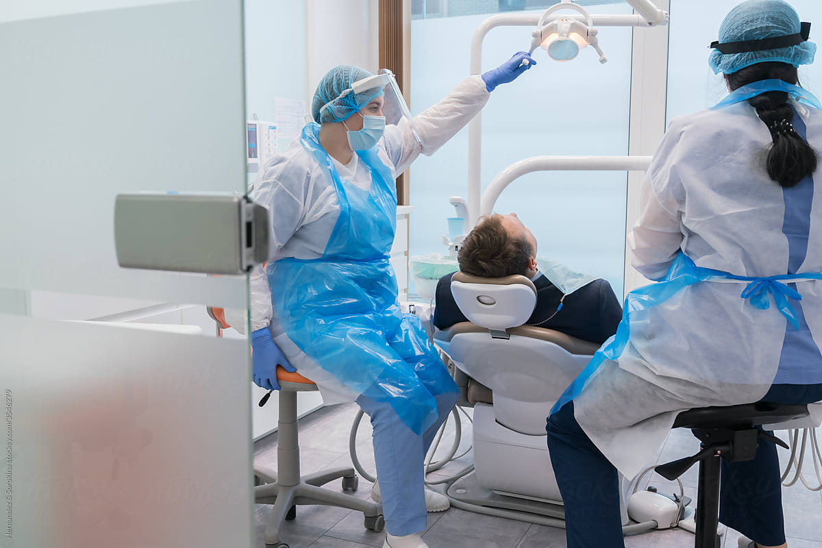 Dentists With A Patient During A Dental Intervention.