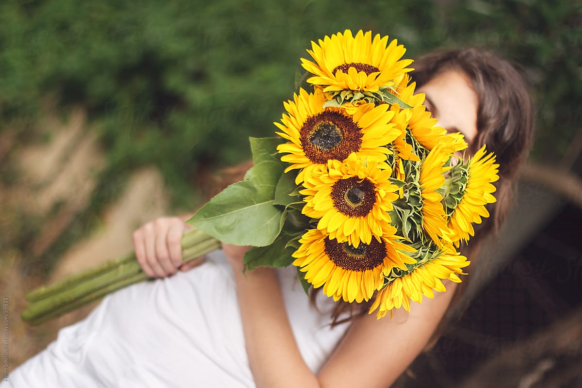 A young lady with a bouquet of sunflowers