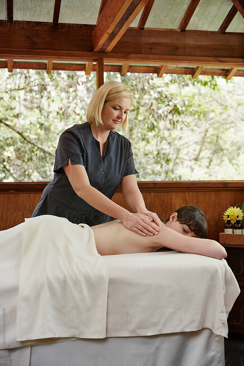 Woman relaxing at spa receiving a massage from massage therapist