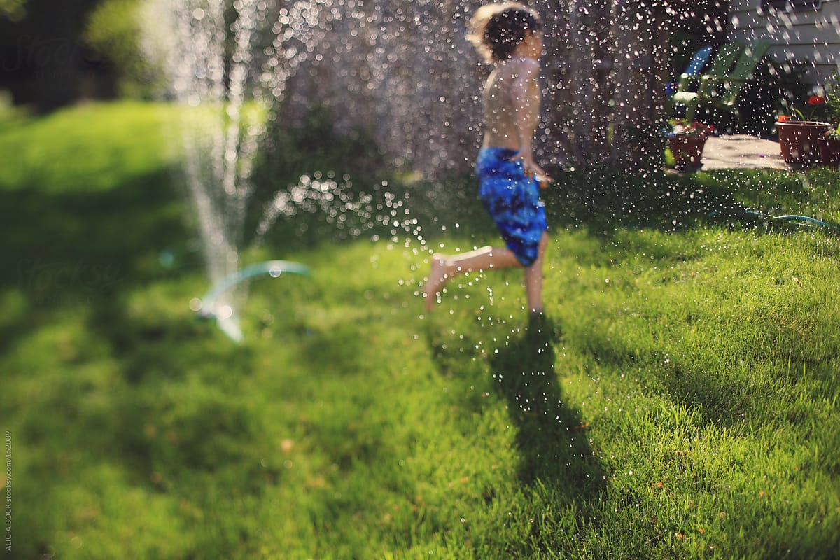 A Boy Enjoys Backyard Sprinkler Fun
