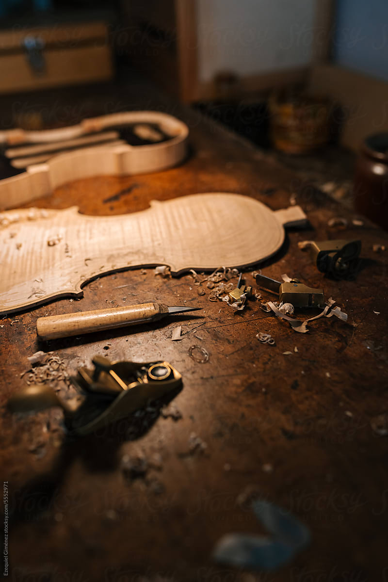 Violin part on workbench with leather tools
