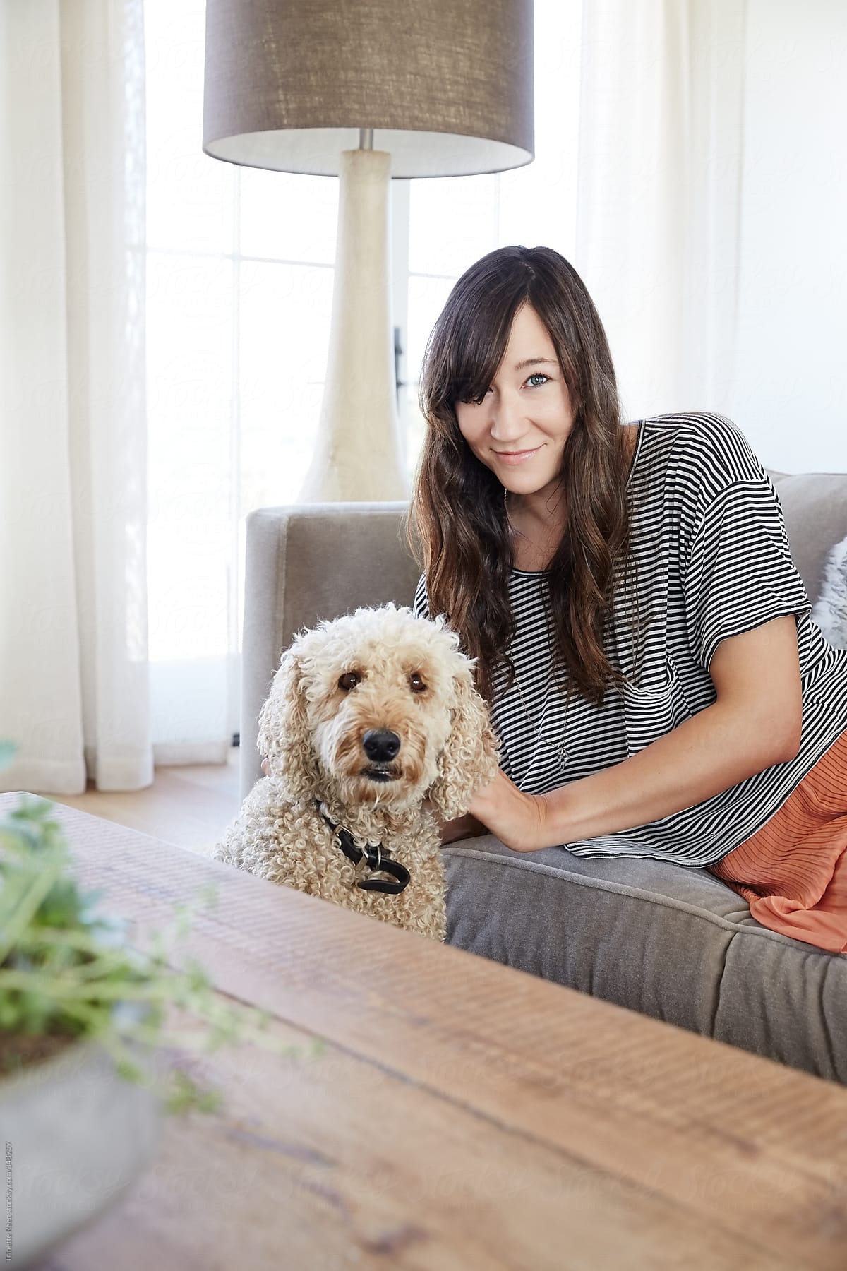 Portrait of woman relaxing in living room with her dog