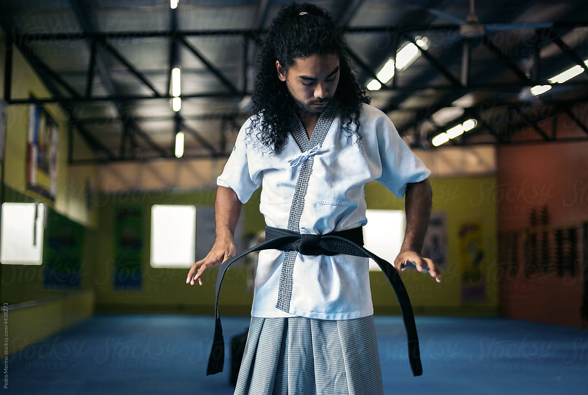 Martial arts fighter tightening on the belt