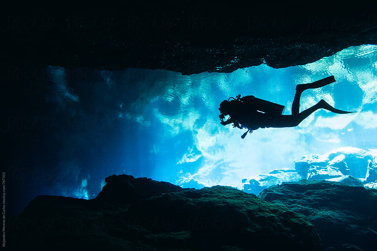 Silhouette of scuba diver doing cave diving in a cenote in Yucatán, Mexico