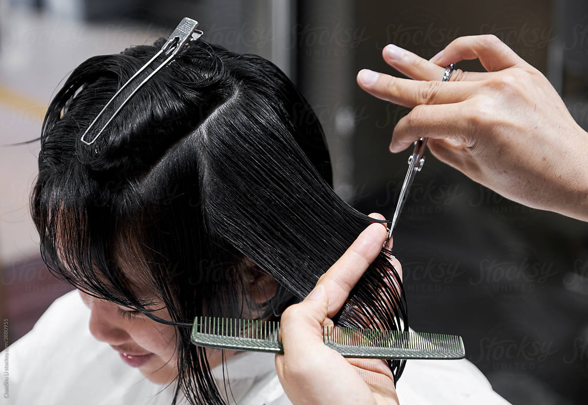Asian Chinese little girl getting a haircut, in a hair salon