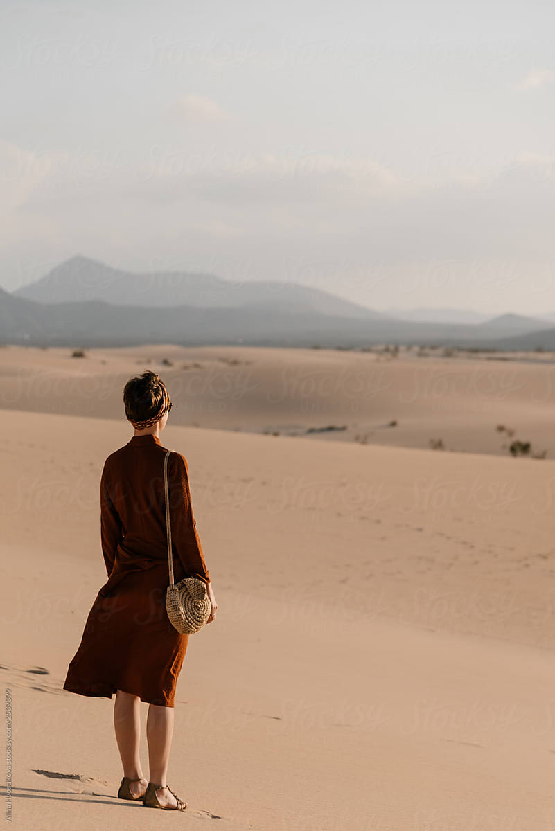 Woman in red dress alone in desert.