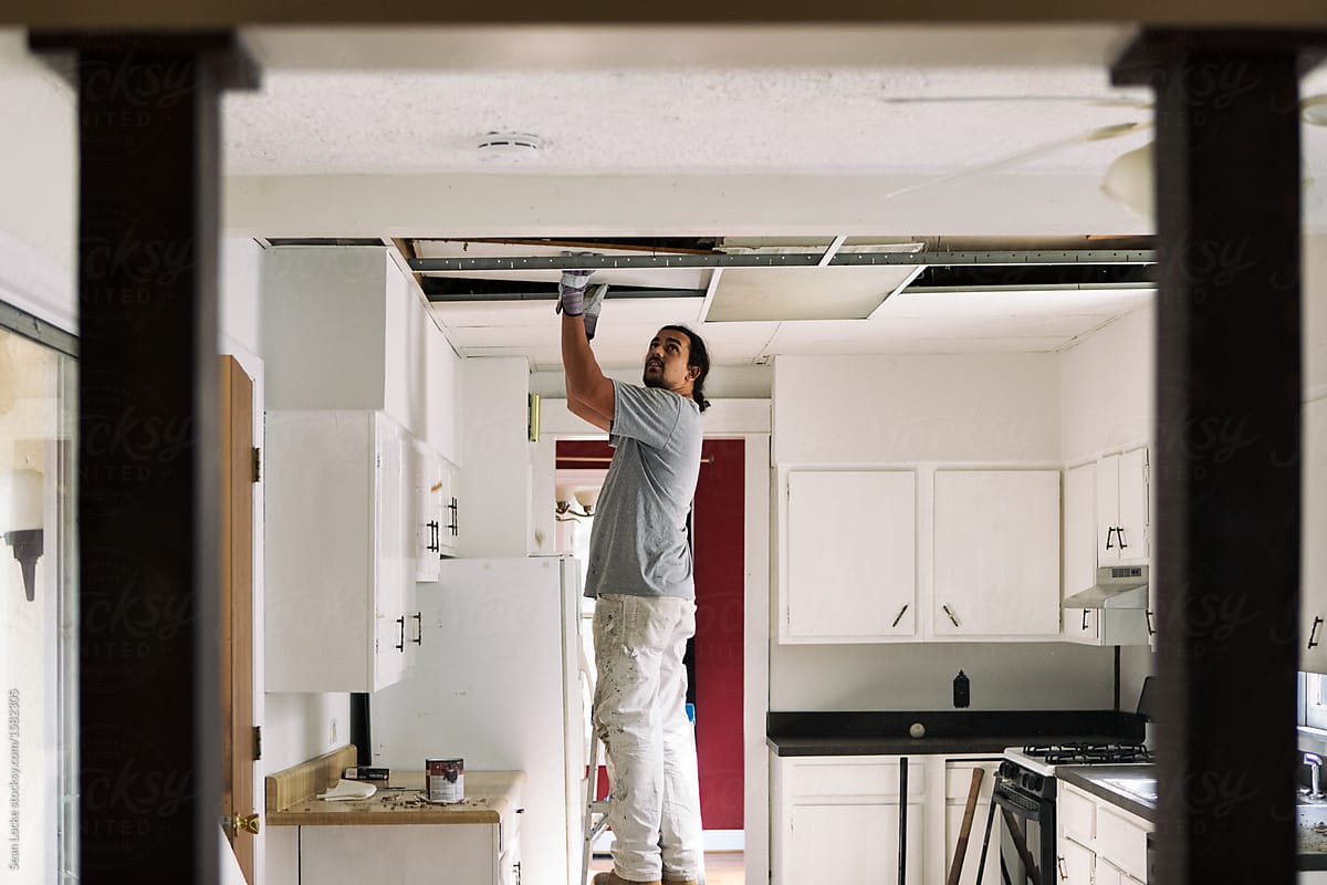 Kitchen Man Removing Drop Ceiling Tiles By Sean Locke